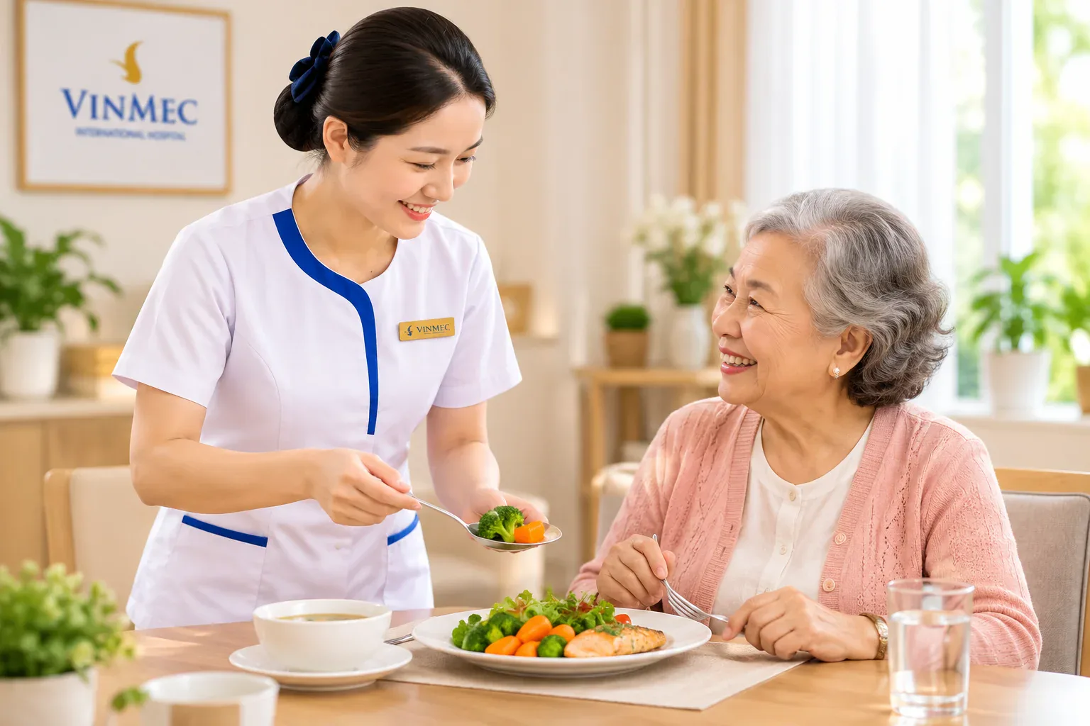 Nhân viên y tế mỉm cười gắp rau cho cụ bà trong bữa ăn