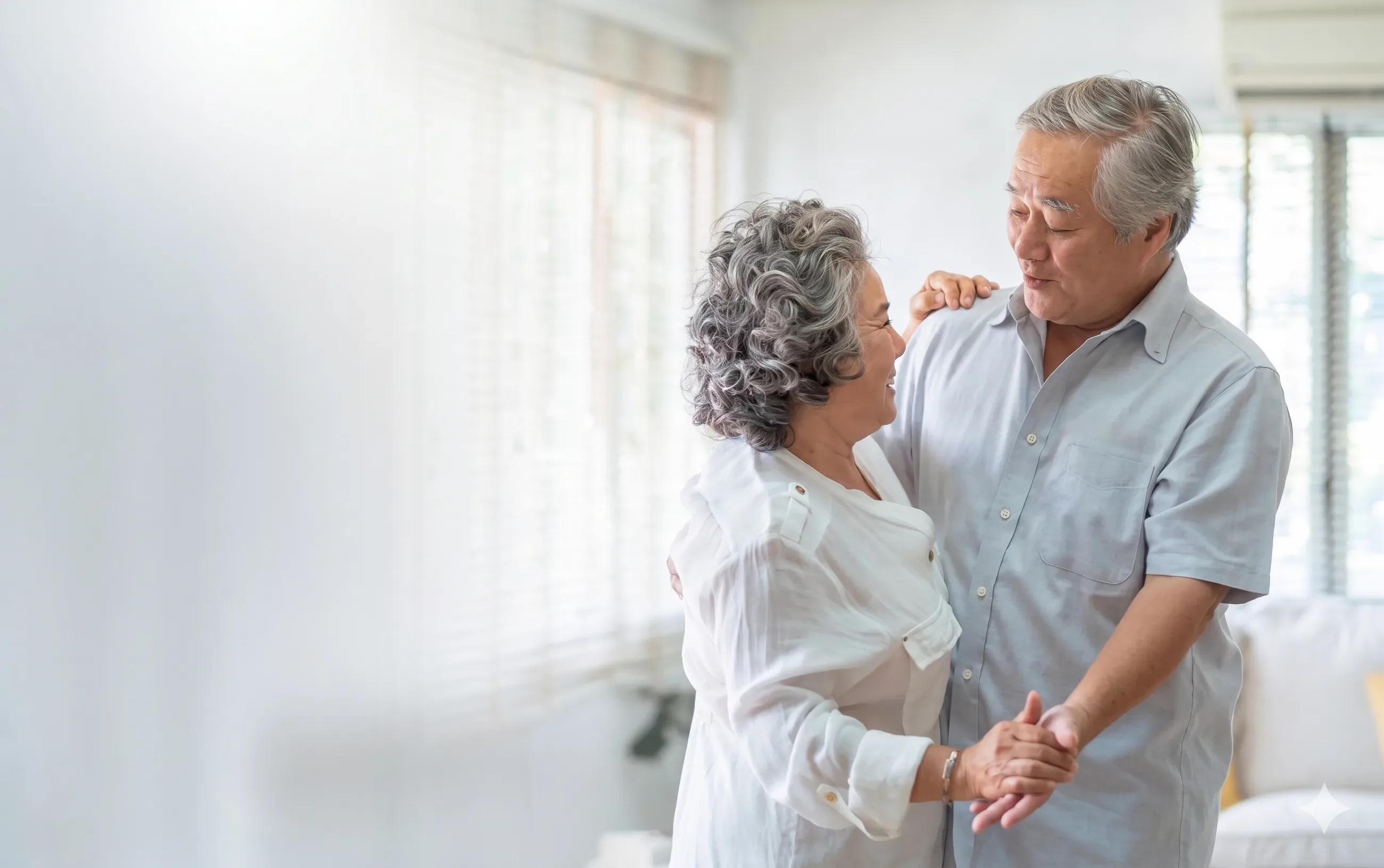 Hai ông bà lớn tuổi nắm tay nhau khiêu vũ bên cửa sổ