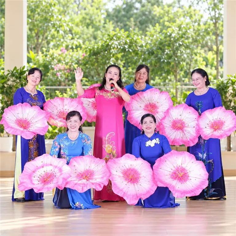 Đội văn nghệ áo dài cầm quạt hoa sen trên sân khấu